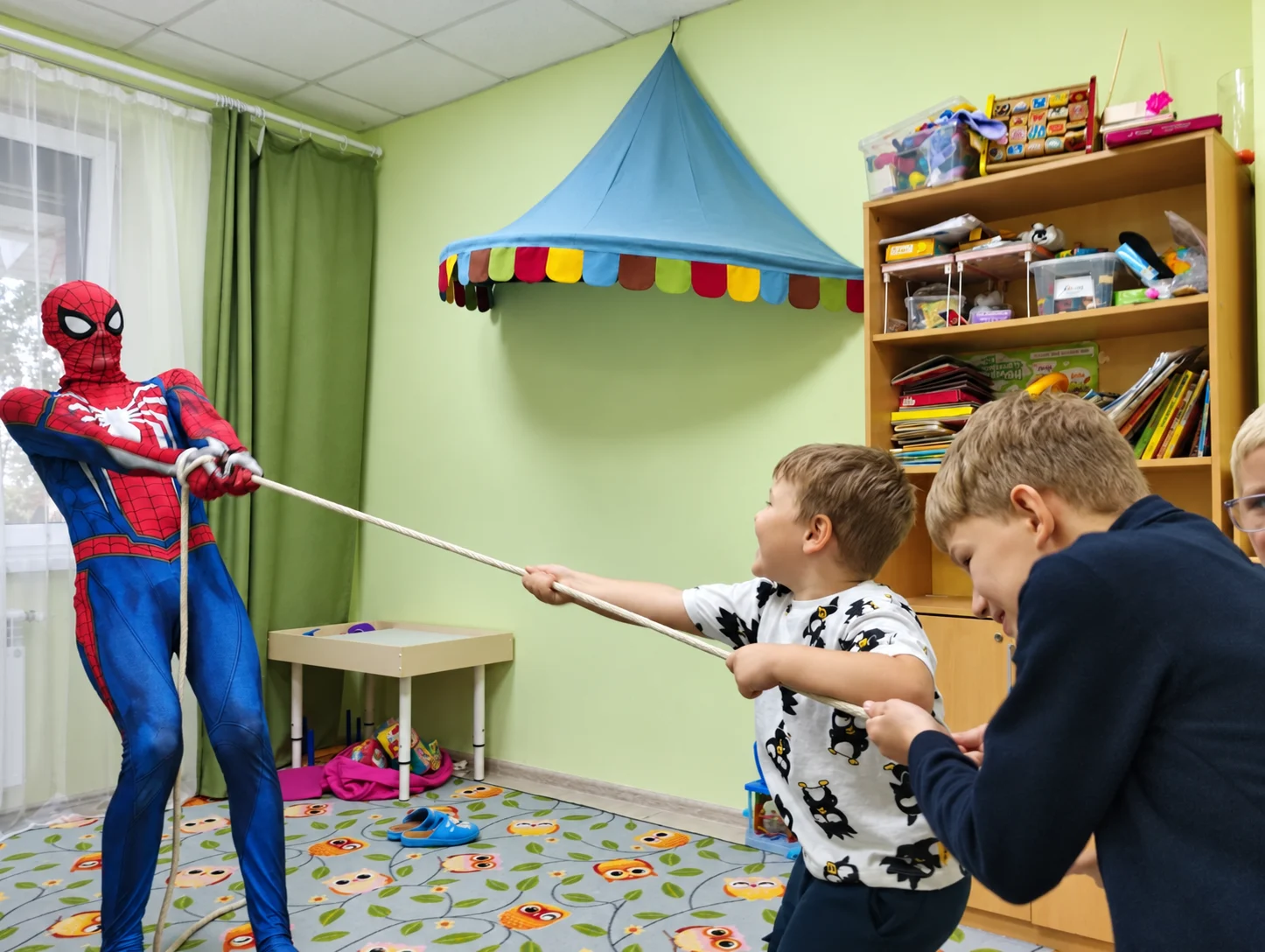 Дети играют с аниматором в костюме Человека-паука